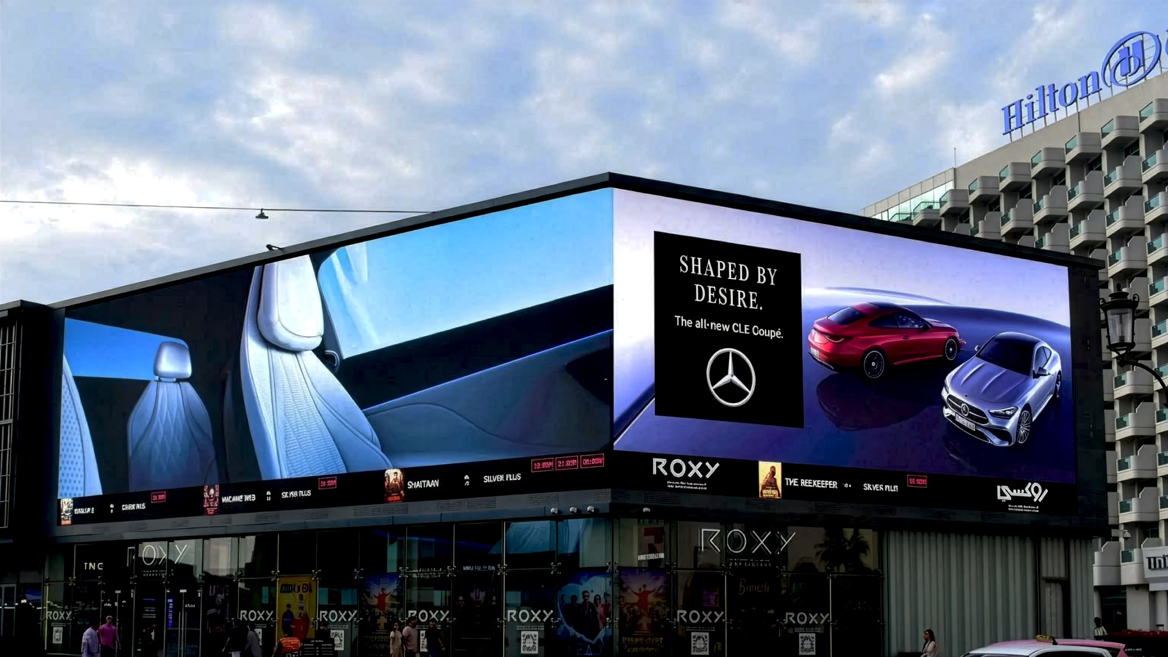 Bvlgari Serpenti digital unipole billboard advertising on a waterfront road in Dubai — luxury jewellery campaign displayed on large-format LED outdoor advertising structure with skyline and sea backdrop.